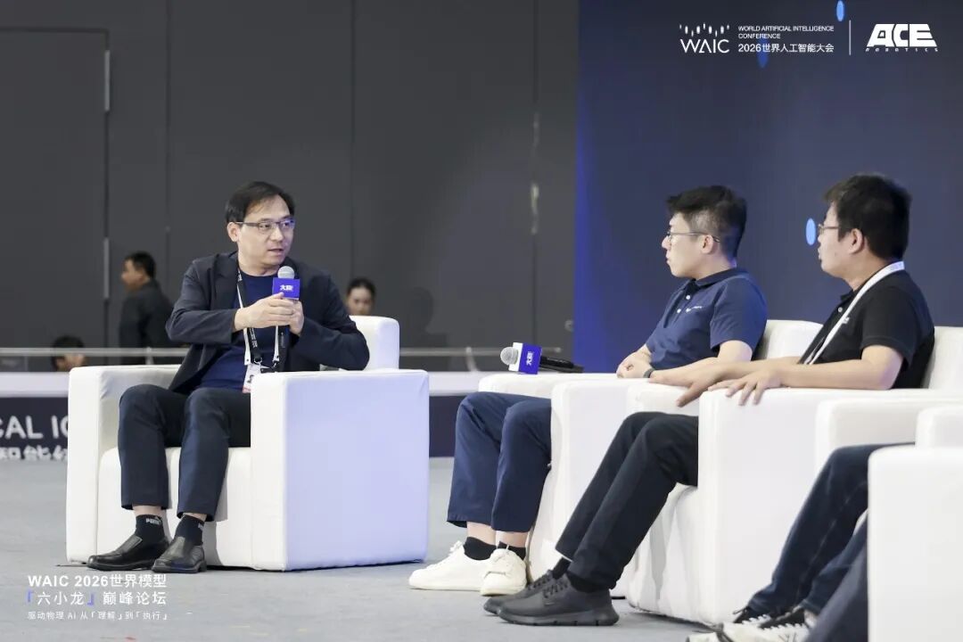 图片展示了WAIC 2026世界模型六小龙巅峰论坛的场景。三位嘉宾坐在白色沙发椅上，中间的嘉宾手持蓝色麦克风正在发言，右侧嘉宾双手交叠，左侧嘉宾双手自然放置。背景为深色，上方有"WAIC 2026世界人工智能大会"字样及"ACE"标识。该图片与文档中对WAIC 2026世界模型论坛的描述相契合，直观呈现了论坛现场情况。